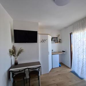 a kitchen and dining room with a table and a small room at Room Mate in Malinska