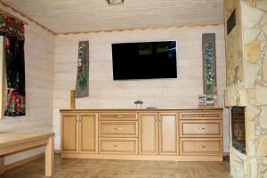 a living room with a tv on a wall at LEŚNY DWOREK 2 in Wołkowyja