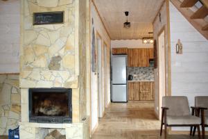 a living room with a stone wall and a fireplace at LEŚNY DWOREK 2 in Wołkowyja