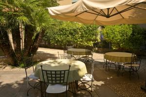 a group of tables and chairs under an umbrella at Alassio Black Loft in Alassio