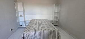 a room with a bed in a room with shelves at Casa Temporada Lua Nova in Guriri +18 photos