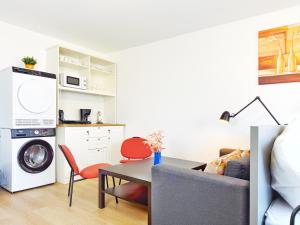 a living room with a table and a kitchen with a washing machine at Langenfeld City Apartment in Langenfeld