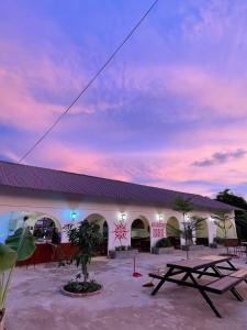 a building with two picnic tables in front of it at Sunrise Bungalows in Kaôh Rŭng (3)