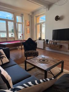 a living room with couches and a pool table at Balcony by Giorgi - Centre de Bastogne in Bastogne