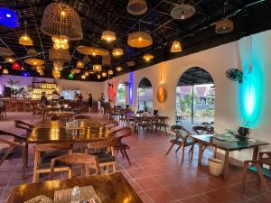a restaurant with wooden tables and chairs and lights at Sunrise Bungalows in Kaôh Rŭng (3)