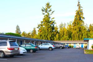 a parking lot with cars parked in front of a building at Stevenson Motel Federal Way near I 5 in Federal Way