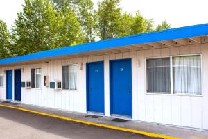 a row of blue doors on a white building at Stevenson Motel Federal Way near I 5 in Federal Way +12 photos