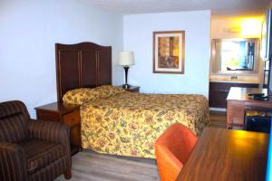 a hotel room with a bed and a chair at Stevenson Motel Federal Way near I 5 in Federal Way
