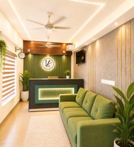 a living room with a green couch and a tv at Levora Suits in Kottayam +22 photos