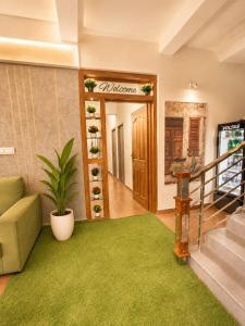 a living room with a couch and a green rug at Levora Suits in Kottayam