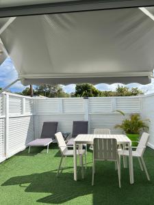 a table and chairs under a white canopy on a patio at chez SAM in Grand-Bourg