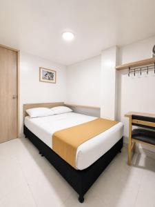 ein Schlafzimmer mit einem Bett, einem Schreibtisch und einem Klavier in der Unterkunft Hotel Adel in Manizales