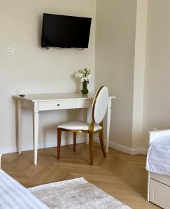 a desk with a chair and a tv on a wall at Hotel Pałac Akropol in Lublin