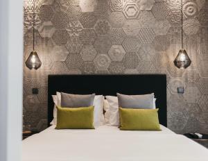 a bedroom with a white bed with two pillows at &Tales Suites - Óbidos in Óbidos