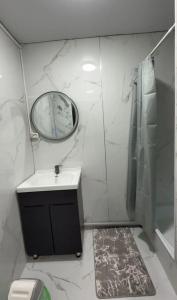 a bathroom with a sink and a mirror and a shower at Janai in Karakol