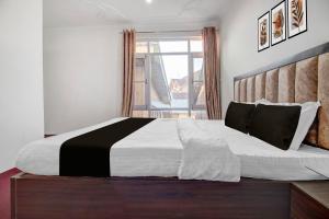 a bedroom with a black and white bed with a window at Hotel O Wave Inn in Srinagar
