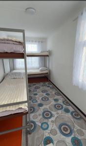 a room with two bunk beds and a tile floor at Janai in Karakol +6 photos