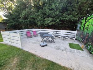 a patio with chairs and a table and a fence at Carabois in Esson