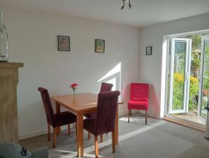 a dining room with a table and a red chair at Little Paradise Marlborough in Marlborough