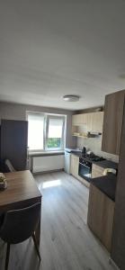 a large kitchen with a table and a dining room at Yellow Apartment Mažeikiai in Mažeikiai