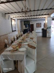 a long table with white tables and chairs in a room at ЕЛІТ in Svalyava
