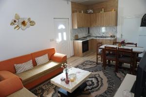 a living room with a couch and a table and a kitchen at Swimming Pool - Leko House Perondi in Kuçovë