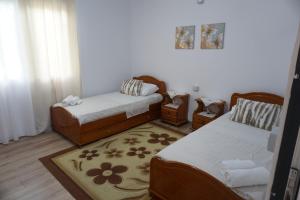 a living room with two beds and a rug at Swimming Pool - Leko House Perondi in Kuçovë