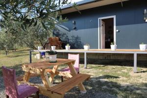 a picnic table and chairs in front of a blue house at Swimming Pool - Leko House Perondi in Kuçovë
