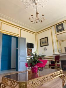 a room with a table with a vase of flowers on it at Hotel du chateau blanc in Saint-Aubin-lès-Elbeuf +20 photos
