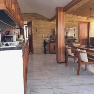 a large kitchen with wooden cabinets and a tile floor at Guest House MM in Saly Portudal +3 photos