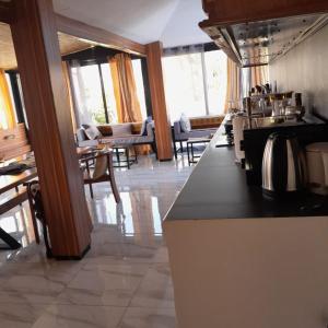 a kitchen with a counter and tables and chairs at Guest House MM in Saly Portudal
