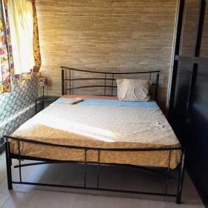 a bed with a metal frame in a room at Guest House MM in Saly Portudal