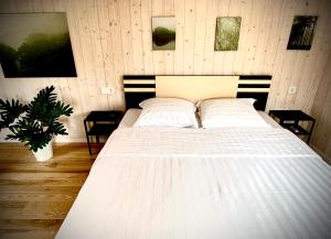 a bedroom with a large white bed with two pillows at Kadaksalu with sauna hinnas in Ruu