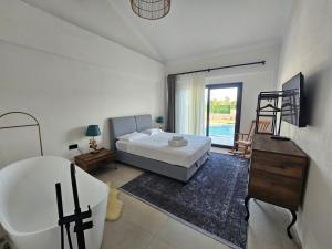 a bedroom with a bed and a bathroom with a tub at Private Pool Villa with Jacuzzi & Garden in Girdev +26 photos
