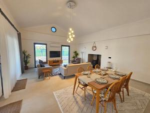 a dining room with a table and chairs in a living room at Private Pool Villa with Jacuzzi & Garden in Girdev