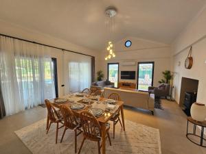 a dining room with a table and chairs and a living room at Private Pool Villa with Jacuzzi & Garden in Girdev