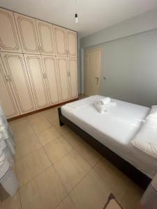 a bedroom with a large white bed with wooden cabinets at Aparthotel Borsh in Borsh