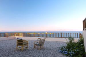 two chairs sitting on the balcony of a house at Oleander Villa in Rafina