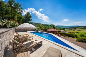 a swimming pool with two chairs and an umbrella at Apartment Ana with private pool in Otok