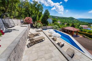 a patio with a pool and chairs and a table at Apartment Ana with private pool in Otok