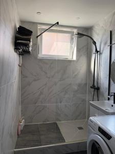 a shower in a bathroom with a window and a washing machine at Location dans résidence privée,sécurisée ,parking gratuit , 1 minute du tramway, à 9 minute du centre ville, accessible à plusieurs transports in Nice