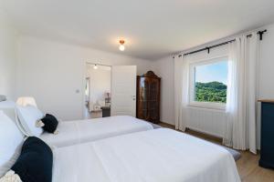 two beds in a white room with a window at Apartment Ana with private pool in Otok +45 photos