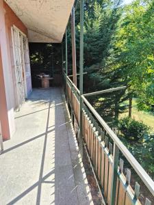 eine Veranda eines Hauses mit einem Holzzaun in der Unterkunft la sequoia in Castagneto Po
