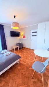 a bedroom with a bed and a table and chairs at MERKADO in Darlowko