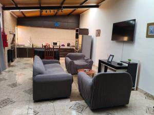 a living room with two chairs and a tv at Yahweh temporarios in Río Grande