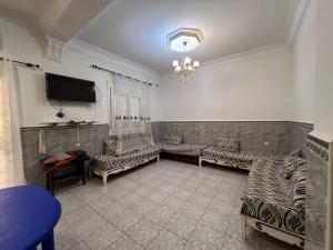 a living room with couches and a flat screen tv at Residence el baraka in Bou Zadjar