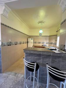 a kitchen with two chairs sitting at a counter at Residence el baraka in Bou Zadjar