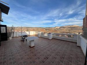 a balcony with a table and bench on a roof at Residence el baraka in Bou Zadjar