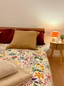 a bed with a colorful comforter and a pillow at UrbanSuite Torino in Turin