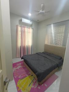 a bedroom with a bed and a window at Serai Homestay in Dungun